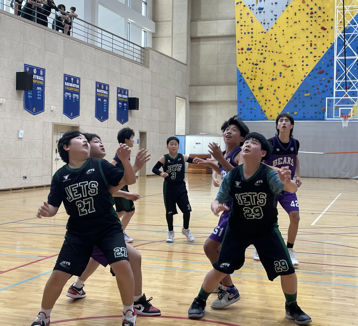 Kevin Ahn (number 27) and Daniel Beck (number 29) box out the opponent for a board. Kevin wins the rebound, takes a drop step, and finishes through defense.